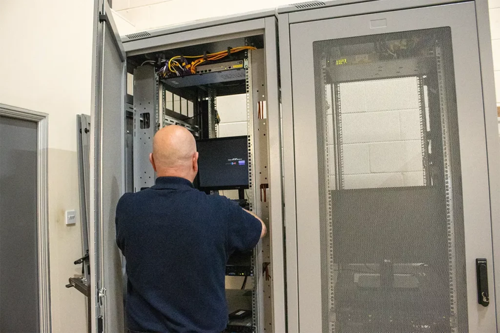 MT Service employee Installing IT infrastructure using a computer in a server cage